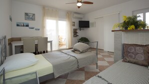 Une chambre avec un lit, un bureau et un téléviseur.