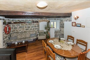Ein Essbereich mit Holztisch, Stühlen und einer Steinwand.