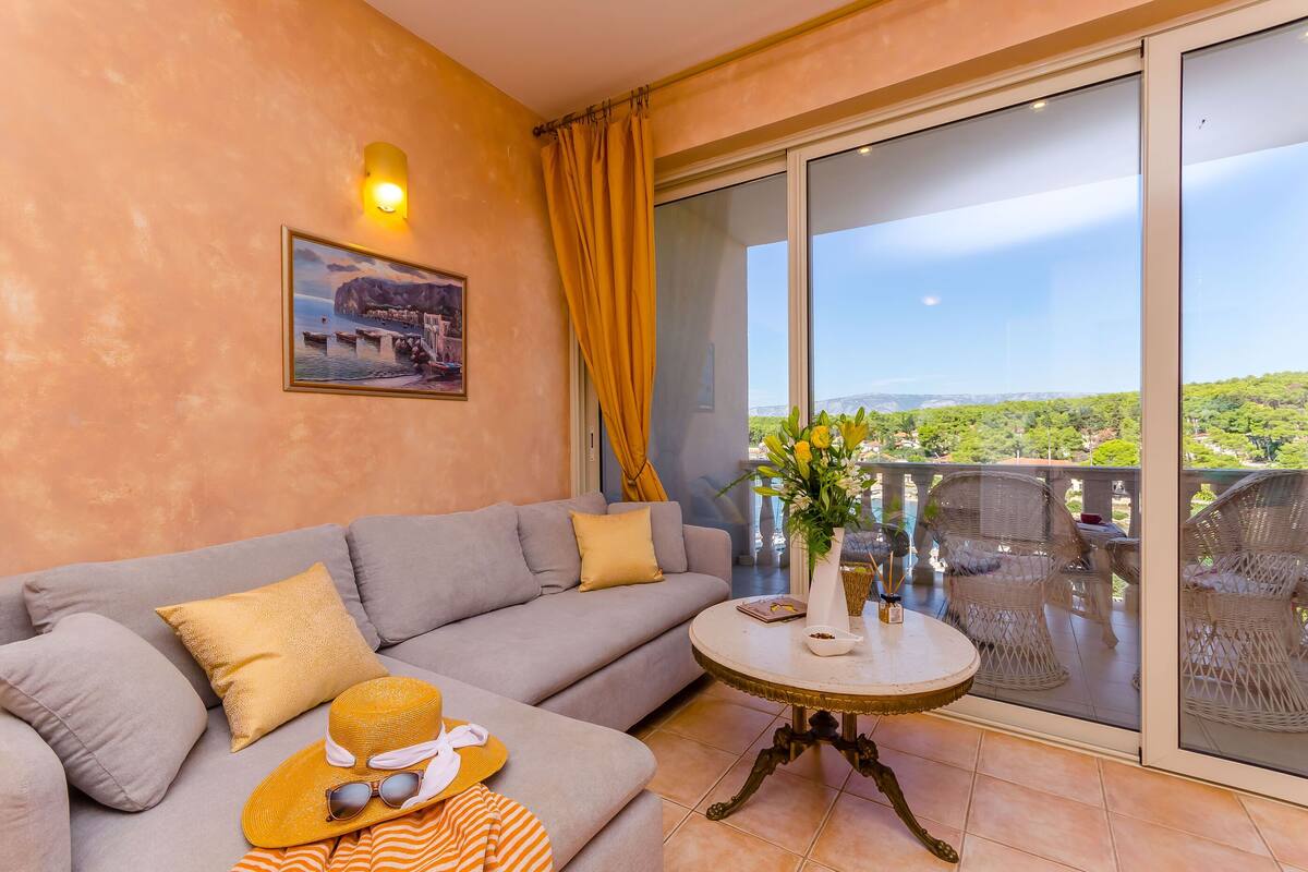 A balcony with a view of greenery and a distant landscape.
