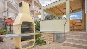 A barbecue grill, outdoor seating area, and a staircase leading to a covered patio. - House Rajka I (Vodice)