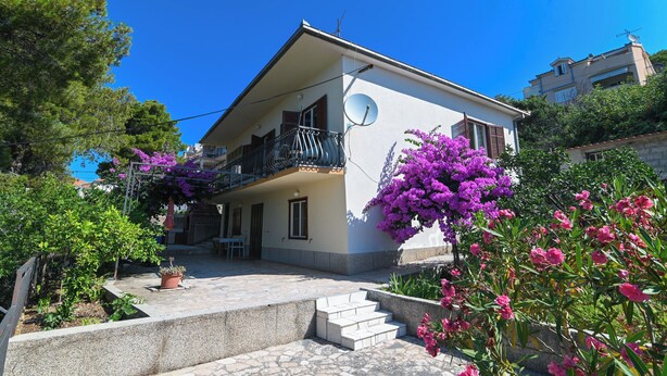 A two-story house with a balcony, satellite dish, and potted plants. - Apartment Katica (Trogir)