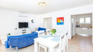 Un soggiorno moderno con divano, televisore e tavolo da pranzo.