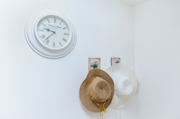 A wall clock with Roman numerals and a white wall. - House Nikolina (Sevid)