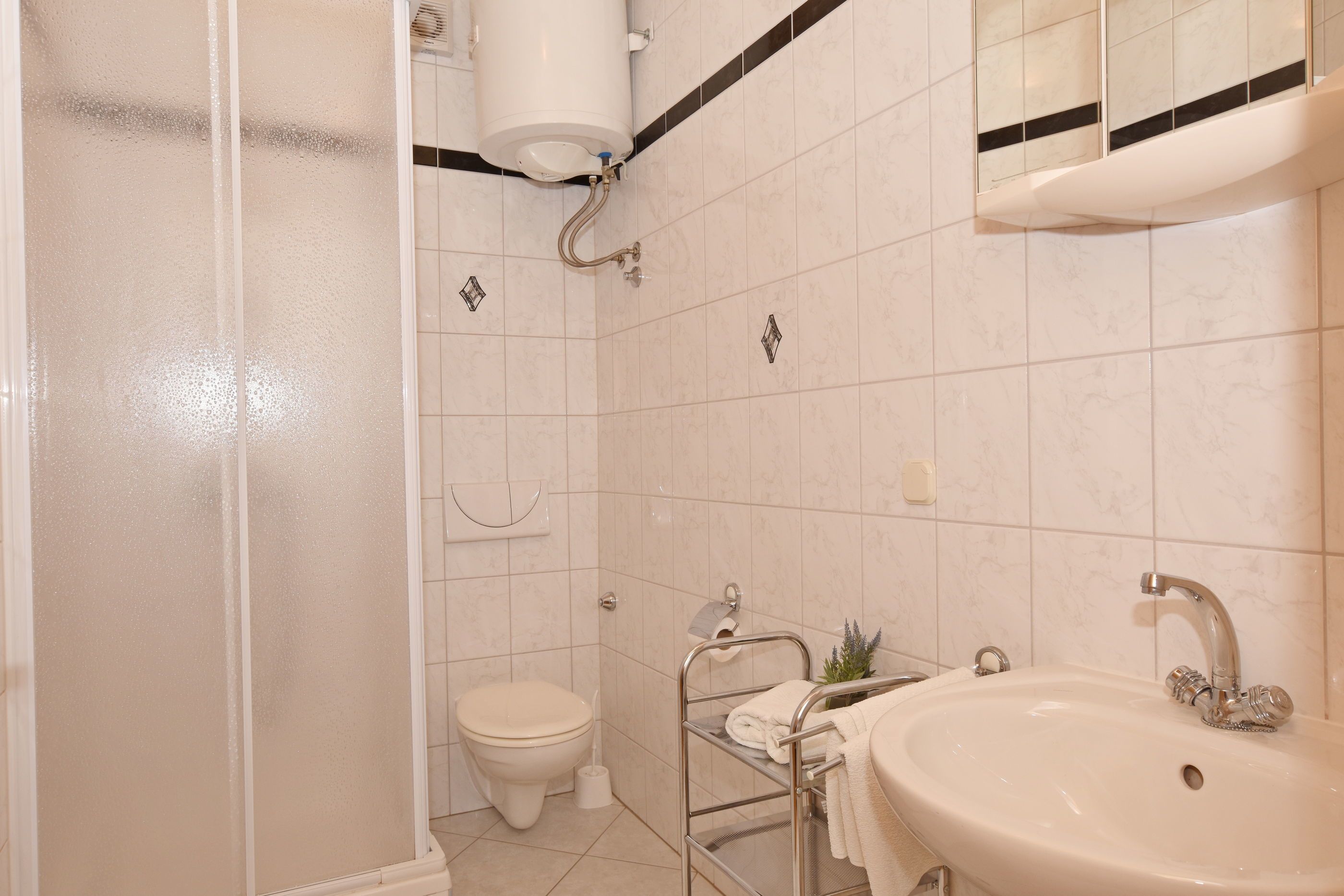 A bathroom with a toilet, sink, and shower.