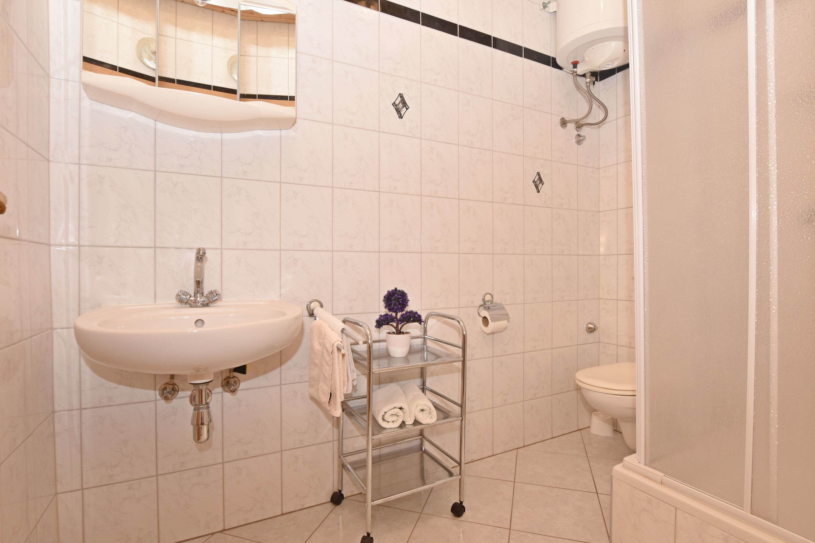 A bathroom with a sink, toilet, and shower.