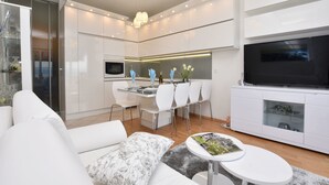 A modern living room with a sofa, a coffee table, and a TV. - Apartment Anja (Jesenice)