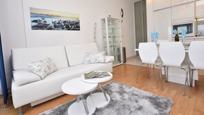 A modern living room with a white sofa, a small round table, and a glass cabinet. - Apartment Anja (Jesenice)