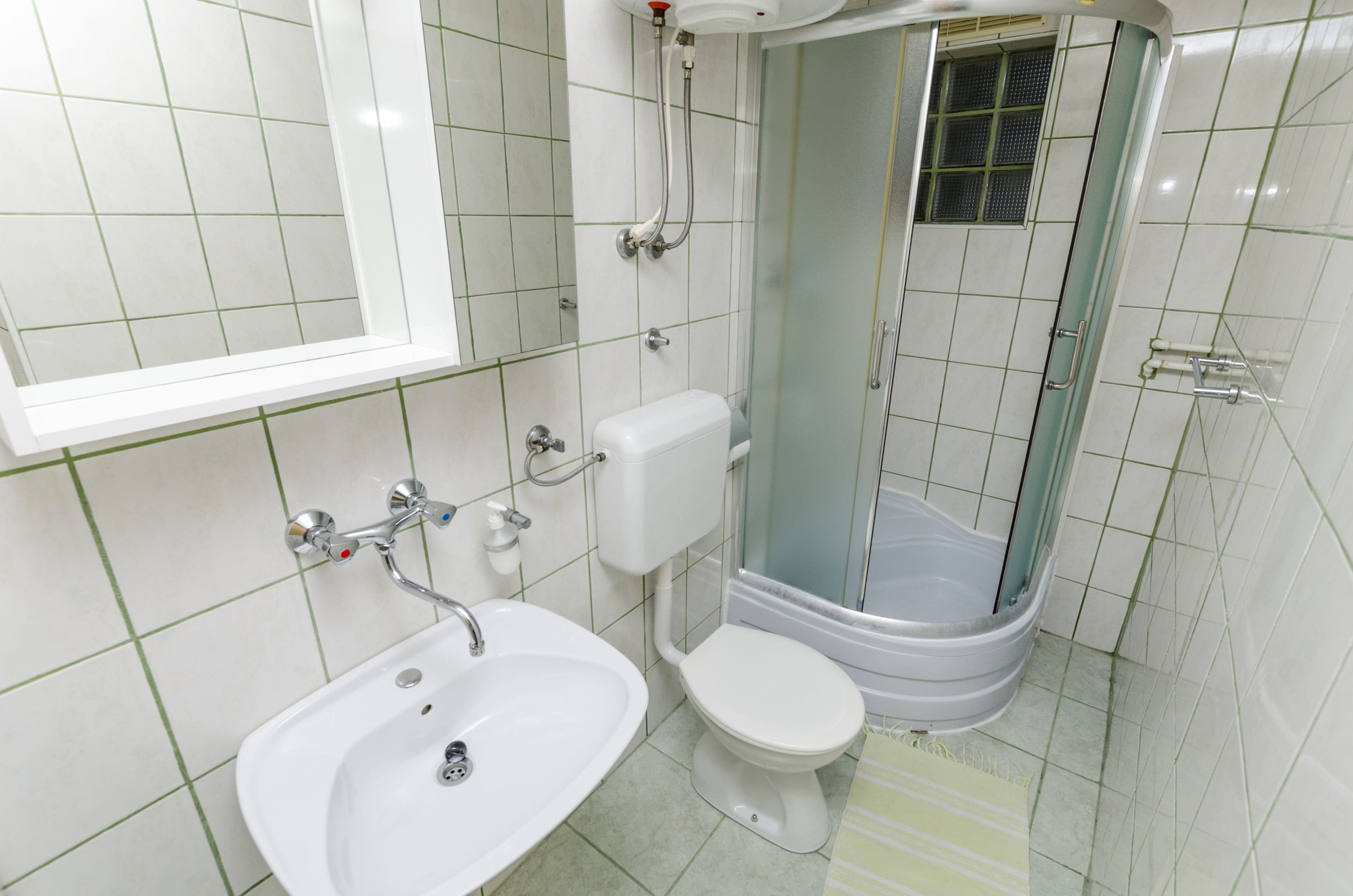 Une salle de bain avec un lavabo, des toilettes et une douche.