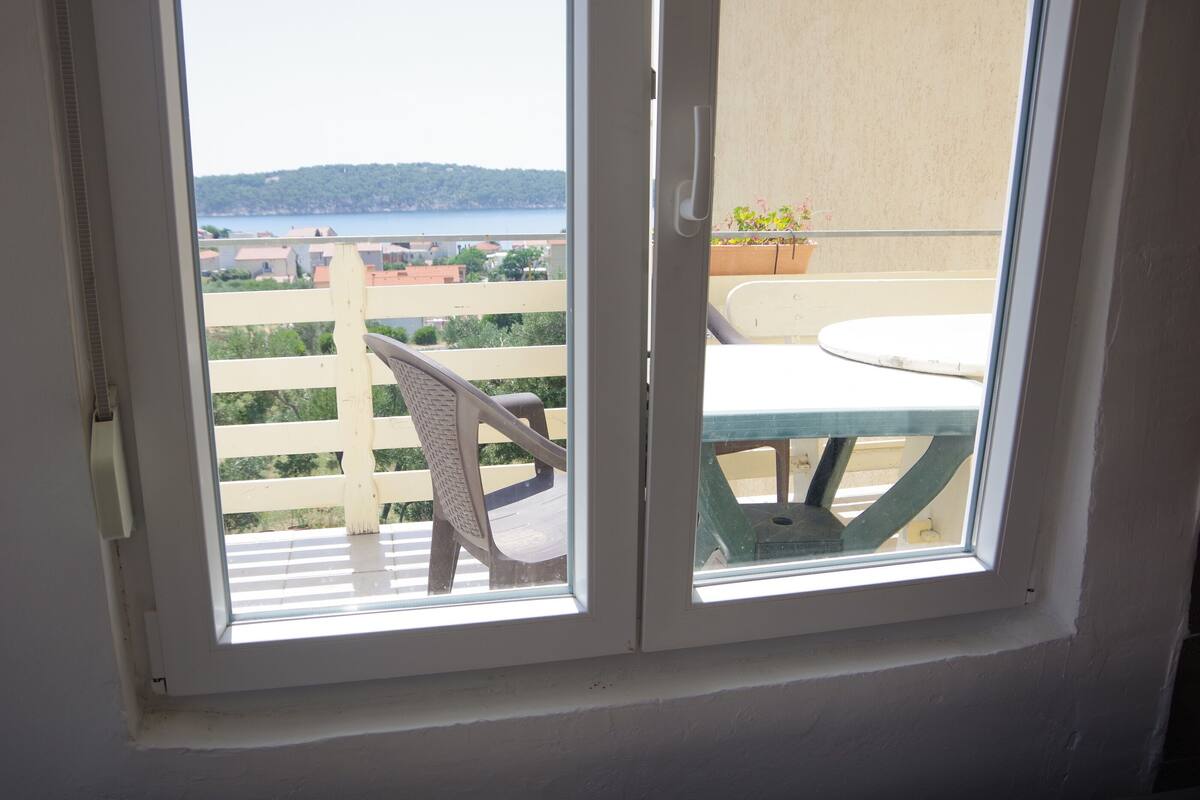 A balcony with a view of a body of water and a distant shoreline.
