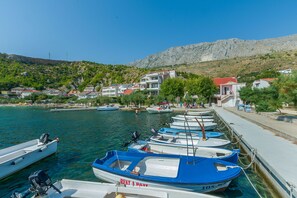 Boats docked along the pier, surrounded by residential buildings with red-tiled roofs.