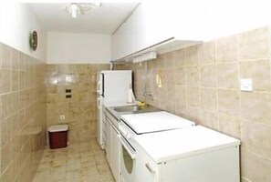 A compact kitchen with a washing machine, a sink, and a small trash bin. - Apartments Edo (Blato)