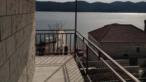 Een balkon met uitzicht op een rustig meer en verre bergen.