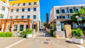 Un bâtiment moderne à plusieurs étages, doté de balcons et d’un espace extérieur couvert avec des poutres en bois.