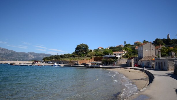 A coastal town with a beach, boats, and buildings. - Apartments Loredana (Lumbarda)