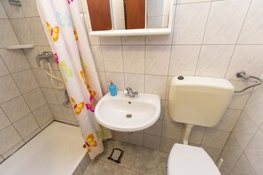 A bathroom with a bathtub, a sink, and a toilet. - Apartments Ksenija (Primosten)