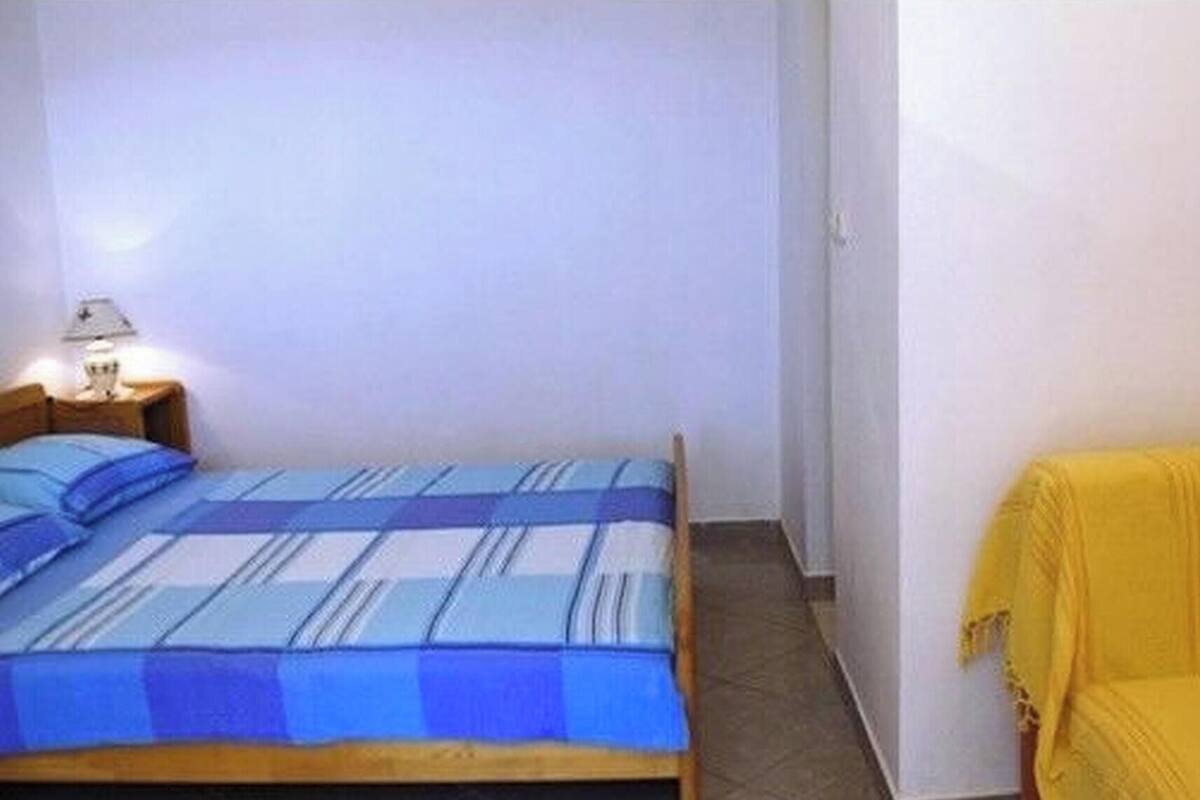 A bedroom with a bed and a yellow sofa.
