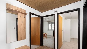 A room with a wooden ceiling, a mirror, a wooden cabinet, and a tiled floor. - Apartments Kralj (Privlaka)