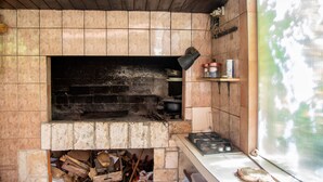A kitchen with a tiled backsplash, a stove, and a window. - Apartment Slavka (Kneza)