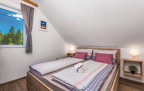 Relax in a serene retreat with a view of the surrounding trees and sky, featuring two comfortable beds and a cozy atmosphere.