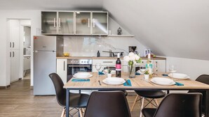 A modern kitchen with a dining area, featuring a built-in oven, microwave, and a stainless steel refrigerator. - 2 bedroom cozy apartment in Ogulin (Ogulin)