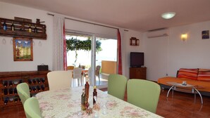 Un coin repas avec une nappe à motifs floraux, des chaises et un meuble à bouteilles.