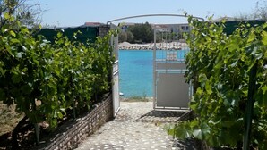 Un sendero que lleva a una zona de piscina bajo un cielo azul despejado.