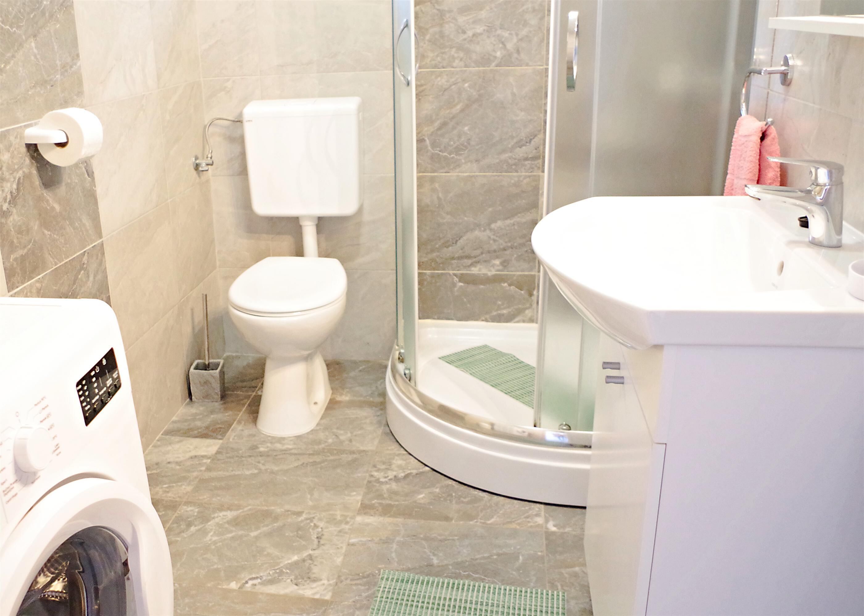 Une salle de bain moderne équipée de toilettes, d’une douche et d’un lavabo.