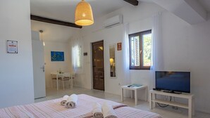 Habitación de hotel con cama, televisión, escritorio y ventana.