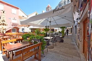 Relax in the charming outdoor café, surrounded by lush greenery and historic stone buildings.
