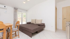Ein Schlafzimmer mit Bett, Stuhl, Tisch und einer Tür.