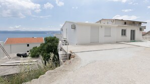 Ein Wohngebäude mit flachem Dach, einem Balkon und Blick auf das Meer.