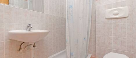 Un baño con lavamanos, cortina de ducha y retrete.