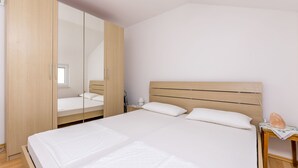 Ein Schlafzimmer mit einem Bett, einem Schrank aus Holz, einem Nachttisch und einem Beistelltisch.