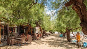 A beachside cafe with outdoor seating and umbrellas. - Apartments and Rooms Denis (Duce)