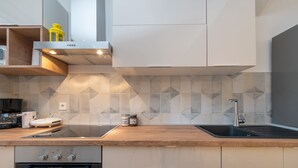 A modern kitchen with a wooden countertop, built-in oven, and a stainless steel sink. - House Polus (Trogir)