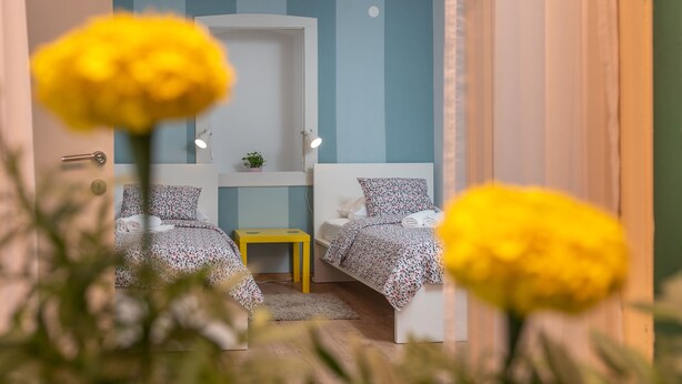 A bedroom with two beds, a small table, and a nightstand. - House Polus (Trogir)