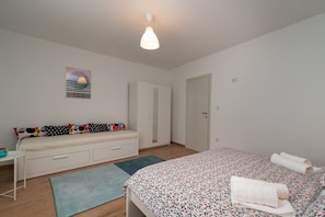 A bedroom with a bed, a sofa bed, a wardrobe, and a small table. - House Polus (Trogir)