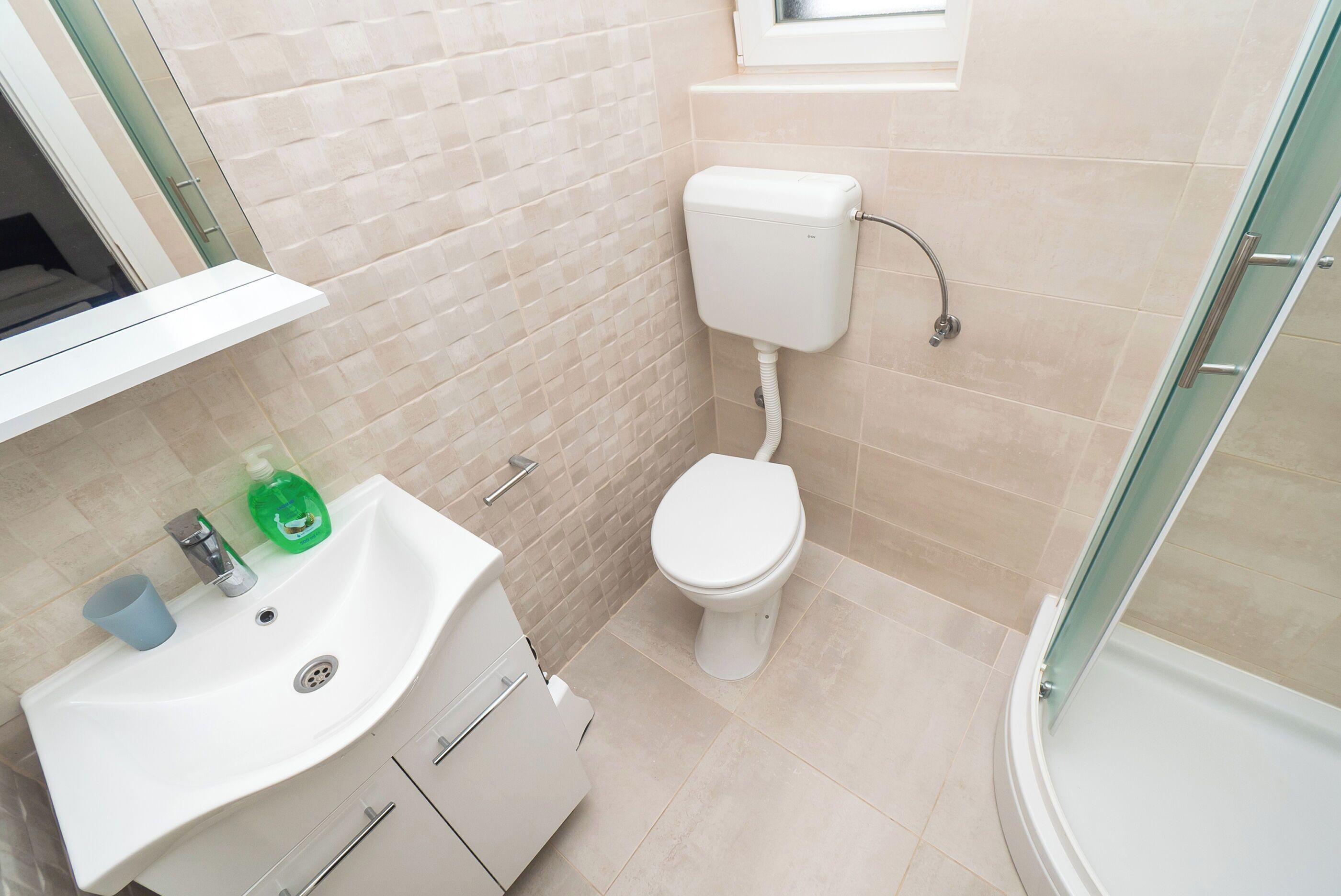 A bathroom with a toilet, sink, and shower.