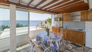 Une cuisine avec des meubles en bois, un four encastré et une vue sur la mer.