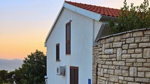 Un bâtiment doté d’un mur en pierre, d’un toit en tuiles et d’une rue pavée de pierres.