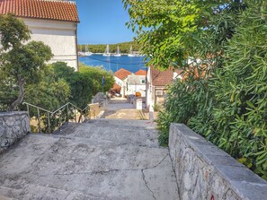 A coastal town with a stone staircase leading to a waterfront area with sailboats. - Apartments Jerkunica (Rogoznica)