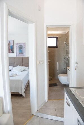 Une chambre d’hôtel avec un lit, une salle de bain avec douche et des toilettes.