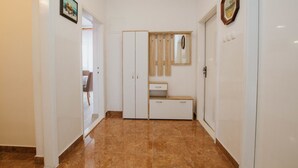 A hallway with a tiled floor, a wooden bench, and a mirror on the wall. - House Josipa (Okrug Gornji)