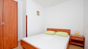 Une chambre à coucher avec un lit en bois, une table de chevet avec une lampe et une armoire.