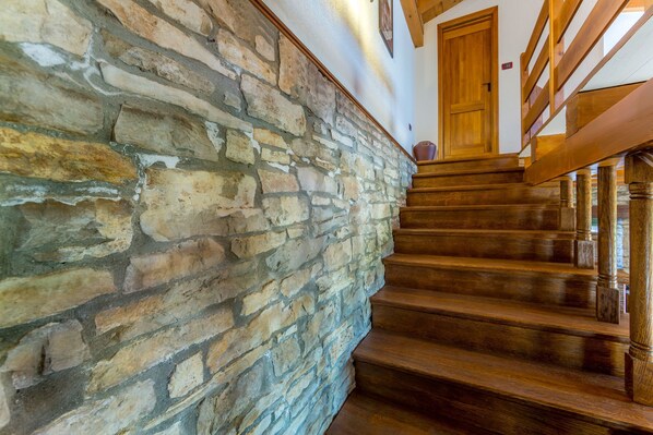 A staircase with wooden steps and a stone wall.