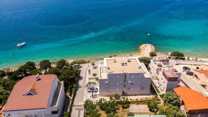 Una zona costiera con vista libera sul mare, una spiaggia sabbiosa e edifici con tetto piatto.