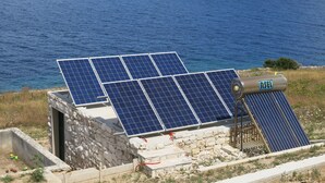 Solar panels installed on a stone structure near a body of water. - House Romantica (Postira)