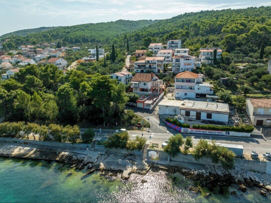 Une vue aérienne d’une ville côtière, avec ses bâtiments, une route et une étendue d’eau.