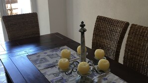 A dining table with a patterned tablecloth, surrounded by wicker chairs. - House Kupina (Gdinj)