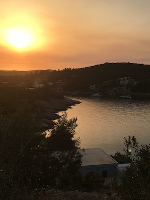 A coastal landscape with a body of water, a hill in the background, and a building in the foreground. - House Kupina (Gdinj)